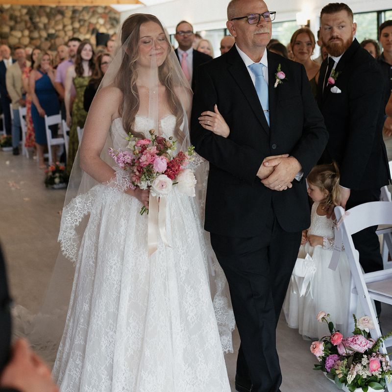 Bride walking down the aisle with her smiling dad